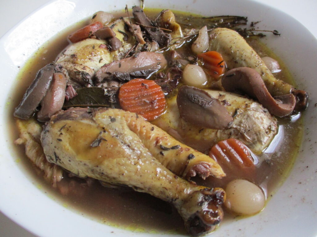 Coq au vin — pula klasike franceze e zier në verë të kuqe me kërpudha dhe qepë