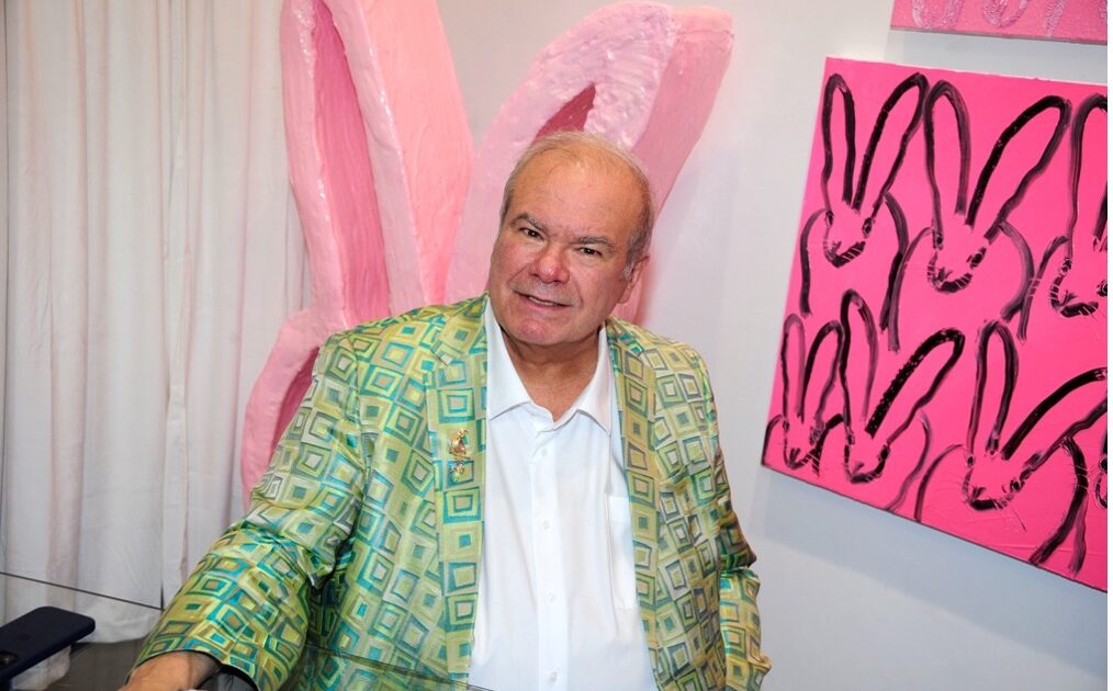 Hunt Slonem next to his rabbit paintings at the "Through the Looking Glass" exhibition in Tribeca. Press photo credit: PMC / Paul Bruinooge.