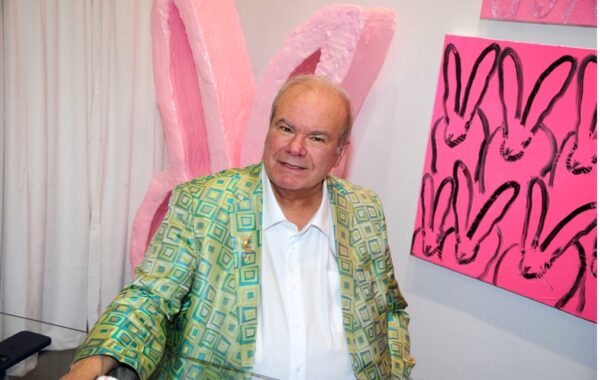 Hunt Slonem next to his rabbit paintings at the "Through the Looking Glass" exhibition in Tribeca. Press photo credit: PMC / Paul Bruinooge.