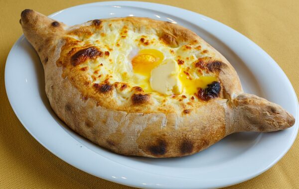 Khachapuri adjaruli — bukë gjeorgjiane në formë varke me djathë, vezë dhe gjalpë
