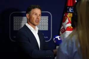 Siniša Mali duke folur për mediat, me flamurin e Serbisë pas tij