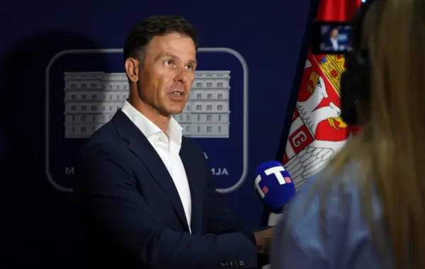 Siniša Mali duke folur për mediat, me flamurin e Serbisë pas tij