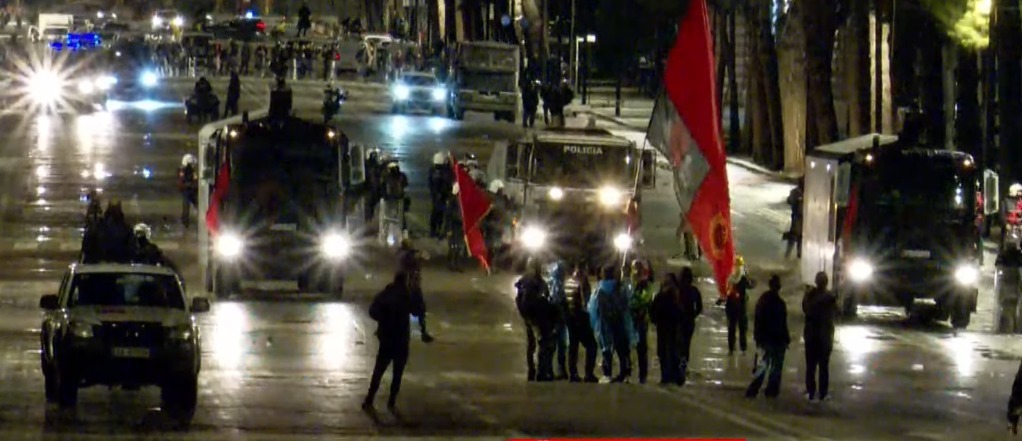 Pas shpërndarjes nga policia  një grup protestuesish me flamuj në duar bëjnë rezistencë përpara autobotit me ujë