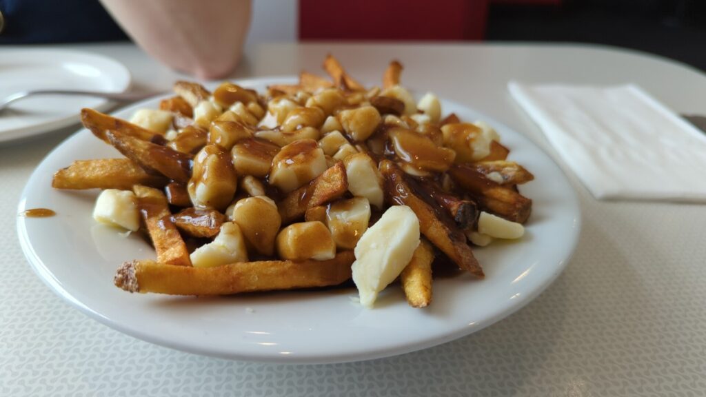 Poutine kanadeze — patate të skuqura me djathë curd dhe salcë gravy